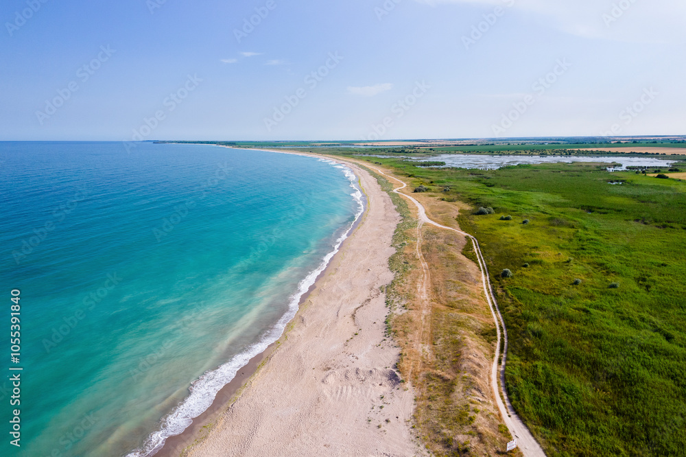 Durankulak, Bulgaria - 12 June 2024: Aerial view of serene Durankulak Beach with tranquil waves and picturesque coastline, Shabla Municipality, Bulgaria. Durankulak, Bulgaria - 12 June 2024: Aerial view of serene Durankulak Beach with tranquil waves and picturesque coastline, Shabla Municipality, Bulgaria.