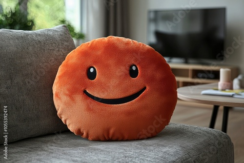 Smiling Orange Plush Pillow on a Gray Couch photo