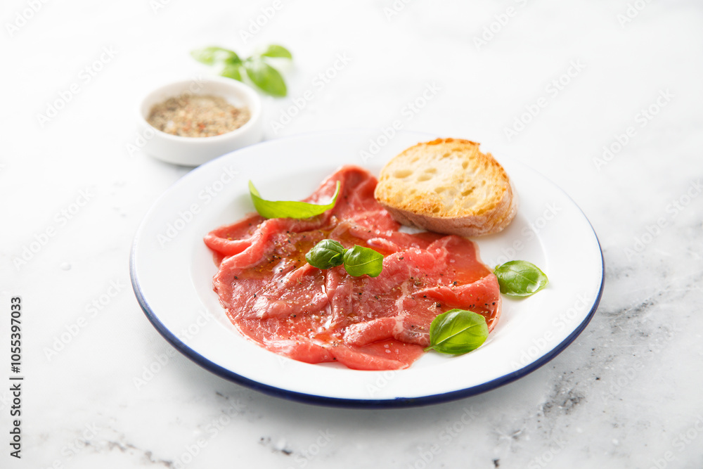 Traditional beef carpaccio with salt and pepper Traditional beef carpaccio with salt and pepper