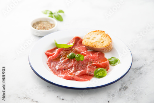 Traditional beef carpaccio with salt and pepper