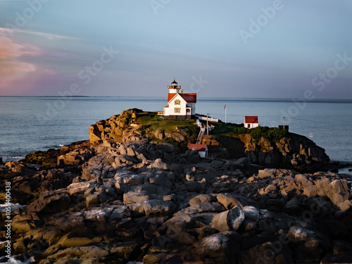 Aerial view of nuble lighthouse at sunrise over the ocean with rocky coast, Cape Neddick, United States. photo