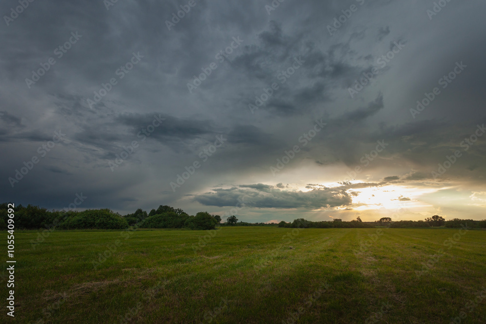 Dark storm cloud and sunlight over the meadow Dark storm cloud and sunlight over the meadow