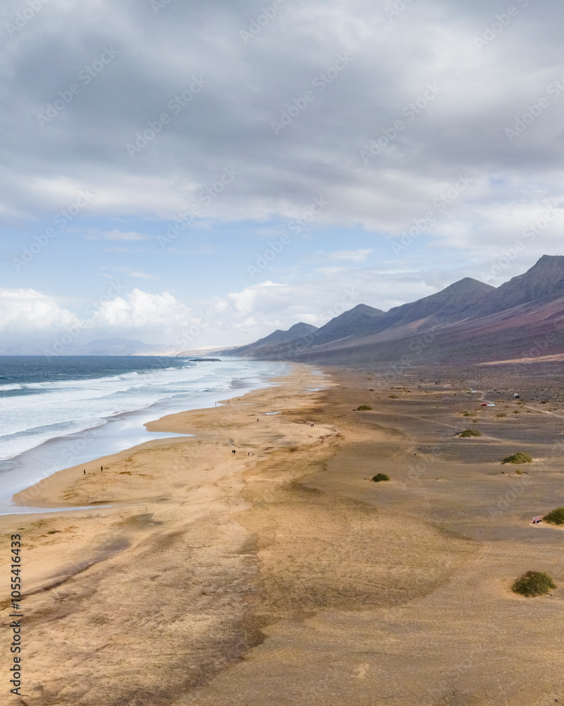 Aerial view of Playa de Cofete, an endless beach along the mountain ridge in Cofete, Fuerteventura, Canary Islands, Spain. Aerial view of Playa de Cofete, an endless beach along the mountain ridge in Cofete, Fuerteventura, Canary Islands, Spain.