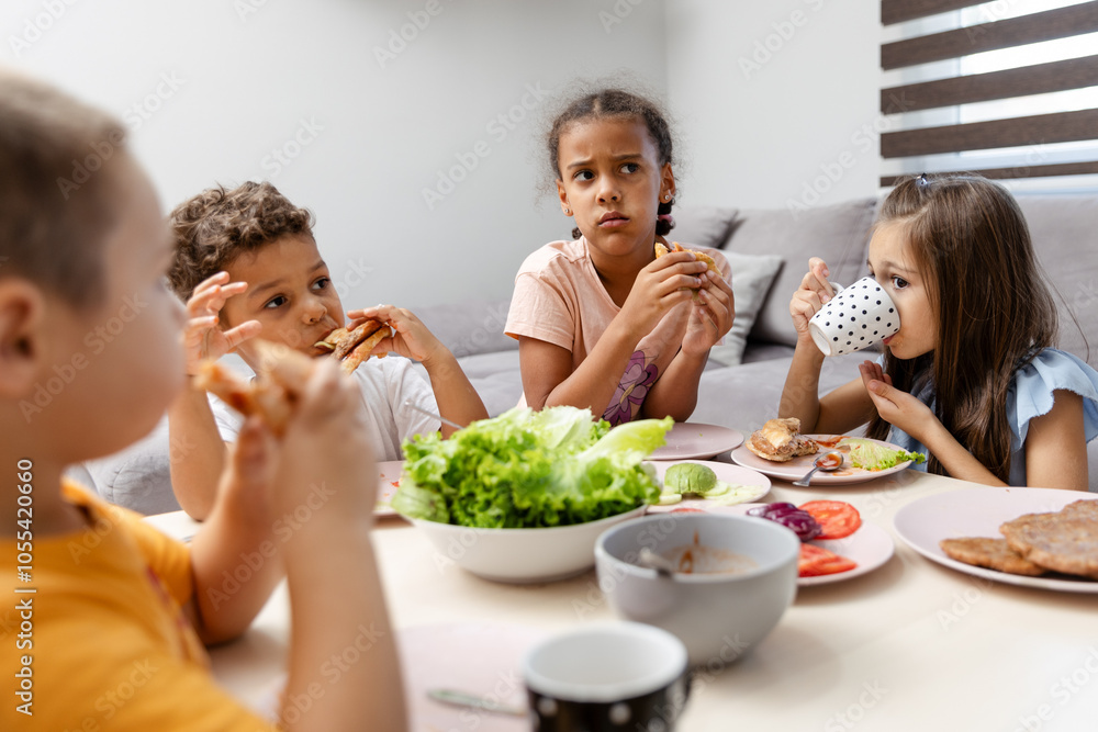 Children enjoying sandwiches at a casual dining table. Children enjoying sandwiches at a casual dining table.