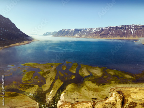 Aerial view of beautiful Langisfor Lake surrounded by majestic mountains and a scenic valley at sunset, Bildudalur, Iceland. photo