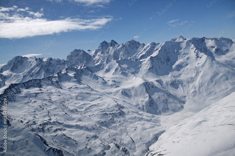 Aerial view of majestic Caucasus Mountains with snowy peaks under a cloudy sky, Kabardino Balkar Republic, Russia. Aerial view of majestic Caucasus Mountains with snowy peaks under a cloudy sky, Kabardino Balkar Republic, Russia.