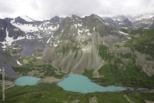 Aerial view of serene Multinskoe lake surrounded by majestic snowy mountains and rugged wilderness, Gorniy Altay Republic, Russia. photo