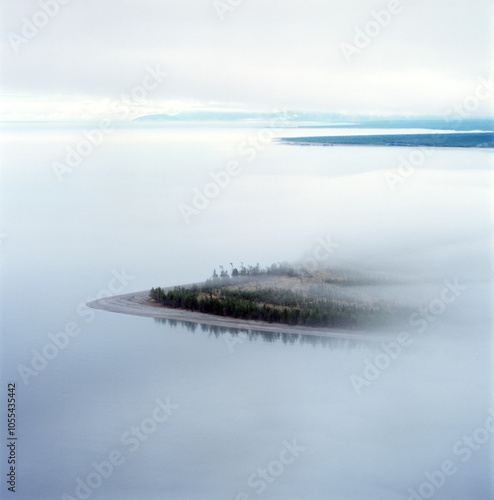 Aerial view of serene lake with fog and an island in a tranquil landscape, eastern siberia, russia.