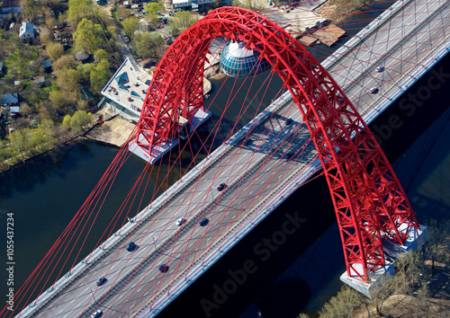 Aerial view of a beautiful red bridge spanning a river with modern cars on a highway, Moscow, Russia.