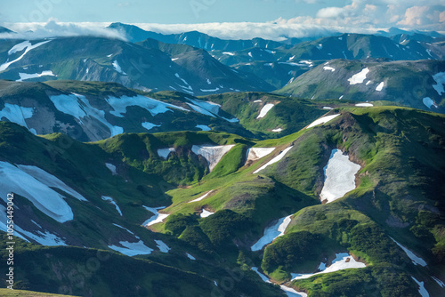 Aerial view of majestic snowy mountains with lush greenery in a vast and pristine landscape, Yelizovo, Russia. photo