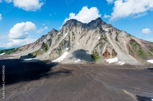 Aerial view of gorely volcano surrounded by rocky terrain and snowy peaks under cloudy sky, Kamchatka Peninsula, Russia. photo