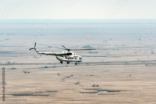 Russia - 10 November 2017: Aerial view of vast and serene open field with a helicopter, Caspian Sea, Russia. photo