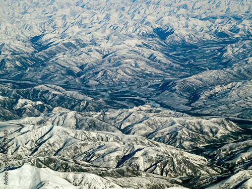 Aerial view of majestic snowy Verkhoyansk Range mountains with a serene valley, Sakha Republic, Russia. photo