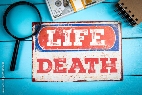 LIFE and DEATH. Metal sign with an inscription on a blue wooden background