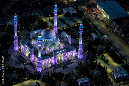 Aerial view of illuminated mosque with majestic minarets and domes in a beautiful nightscape, Shali, Russia. photo