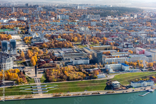 Aerial view of autumn cityscape with beautiful buildings and a river surrounded by trees, Oktyabr'skiy, Izhevsk, Russia. photo