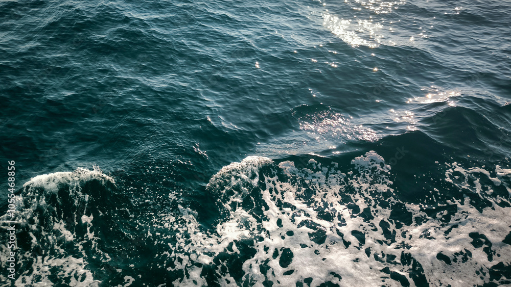 Naklejka premium sea water with waves, white foam and reflection texture background