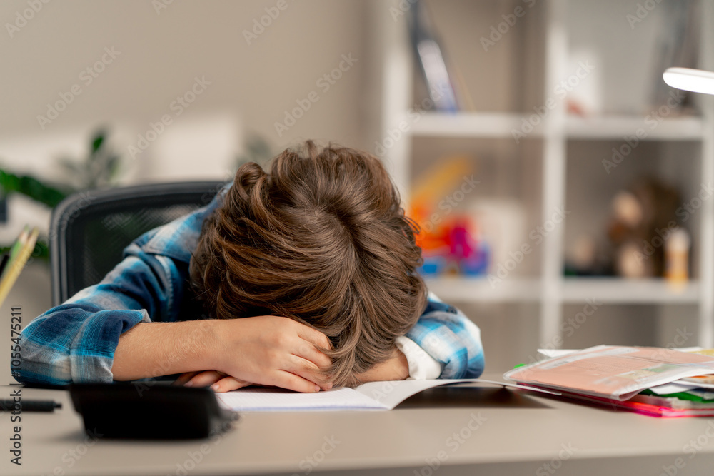 close up in the children's room a schoolboy in white sweater and a blue checkered shirt lies on a desk behind his head a difficult task children's suffering distressed feelings close up in the children's room a schoolboy in white sweater and a blue checkered shirt lies on a desk behind his head a difficult task children's suffering distressed feelings