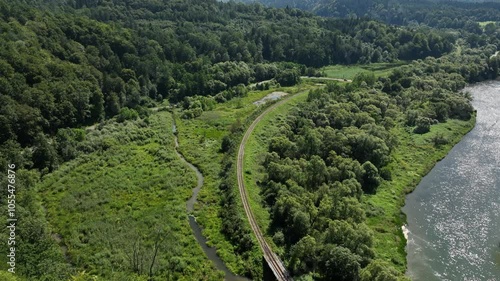Drone flight in the mountains along the railway tracks among trees and greenery. Mavic 3