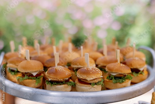 Fotografia Mini burgers on a tray with garden backdrop