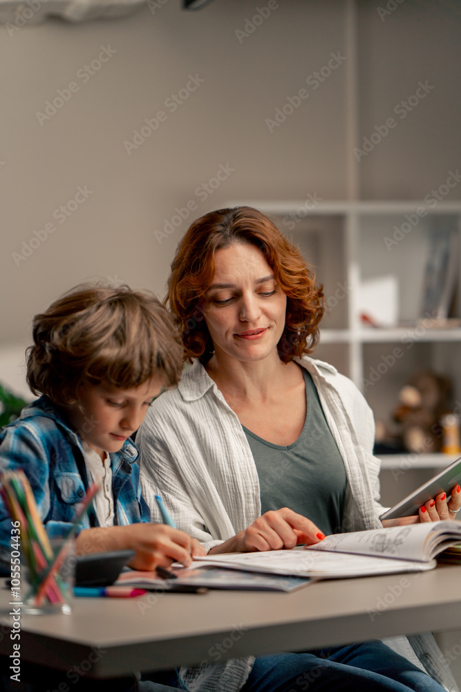in the children's room a schoolboy in a white sweater and a blue checkered shirt at desk does homework mom explains the task in the children's room a schoolboy in a white sweater and a blue checkered shirt at desk does homework mom explains the task