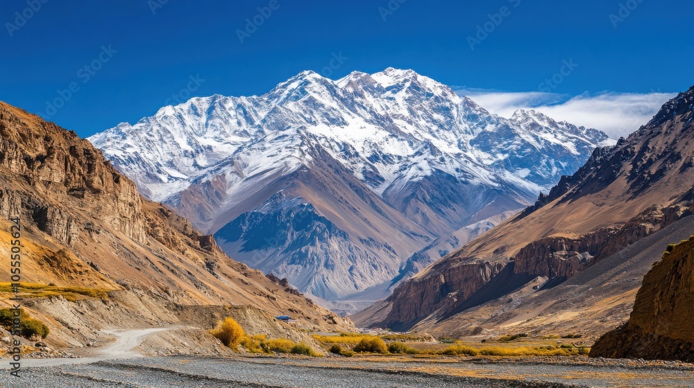 Snow-capped mountains under a clear, blue sky, with rugged cliffs and valleys Snow-capped mountains under a clear, blue sky, with rugged cliffs and valleys
