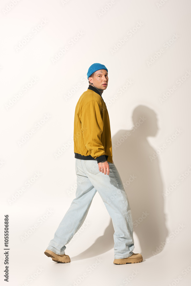 A tattooed young man walks confidently in a stylish jacket and casual pants. A tattooed young man walks confidently in a stylish jacket and casual pants.