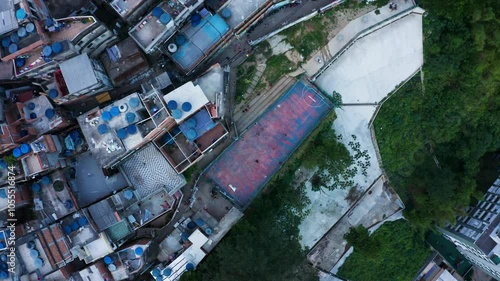 Aerial view of vibrant favela with people playing football among colorful rooftops, Rio de Janeiro, Brazil.