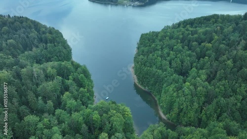 Flying over a lake with a visible headland surrounded by dense forest. Mavic 3