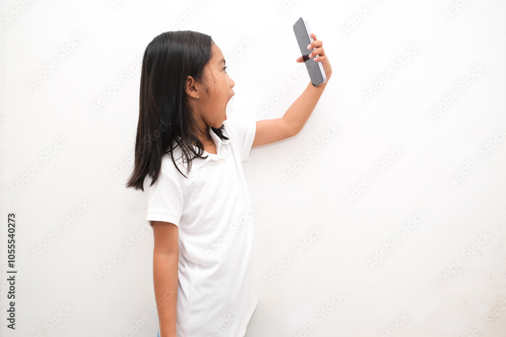 Young lady looks at phone screen in front of eyes in surprise. Girl with headphones opens mouth shocked by information in gadget looking at picture Young lady looks at phone screen in front of eyes in surprise. Girl with headphones opens mouth shocked by information in gadget looking at picture