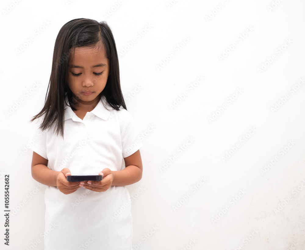 beautiful asian little girl on white background holds mobile phone, uses modern cellular beautiful asian little girl on white background holds mobile phone, uses modern cellular