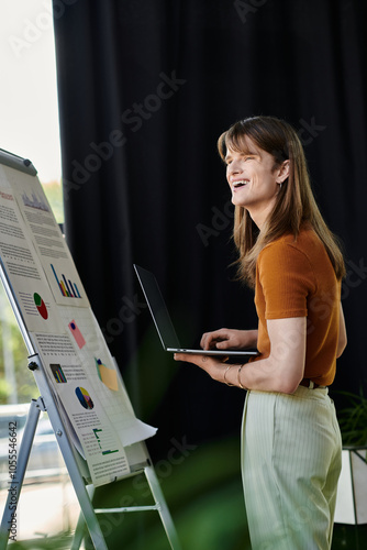 A young non binary person engages with a laptop while presenting colorful charts and data. photo