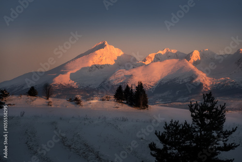 snowy and illuminated peak of Krivan near Podbanske in winter at sunset photo