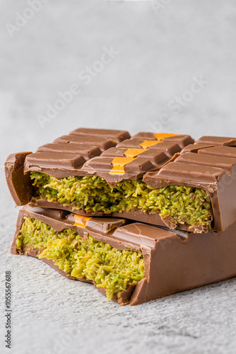 Dubai Chocolate bar with green kadayif and peanut butter on white stone table photo