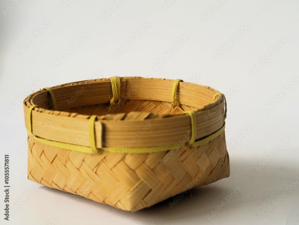 Obraz premium Indonesian traditional besek or a food container made of woven bamboo isolated white background. DIY food container usually used for traditional event