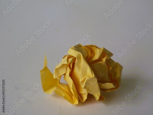 A crumpled piece of paper that has been squeezed and twisted out of shape. isolated white photo