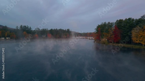 Aerial view of serene North Pond surrounded by tranquil autumn foliage and misty forest, Bethel, United States of America.