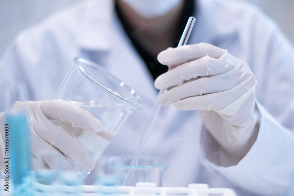 Close-up scientist pouring blue liquid into test tube beaker flask ...