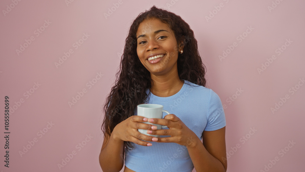 Young woman smiling while holding a coffee cup over an isolated pink background Young woman smiling while holding a coffee cup over an isolated pink background