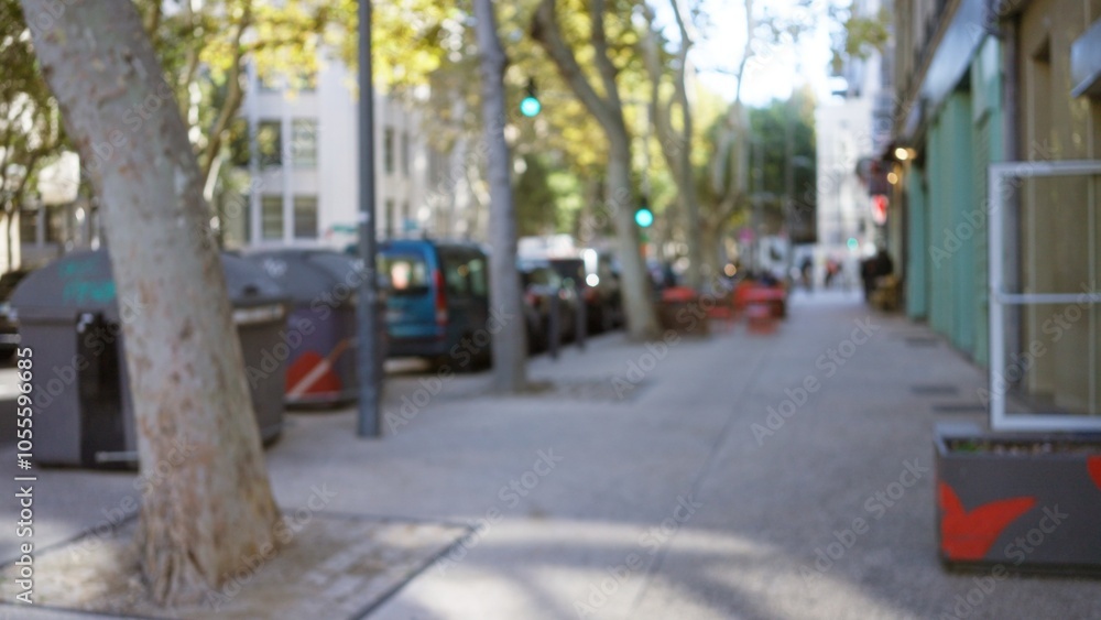 Blurred street scene in marseilles, france, with trees and parked cars ...