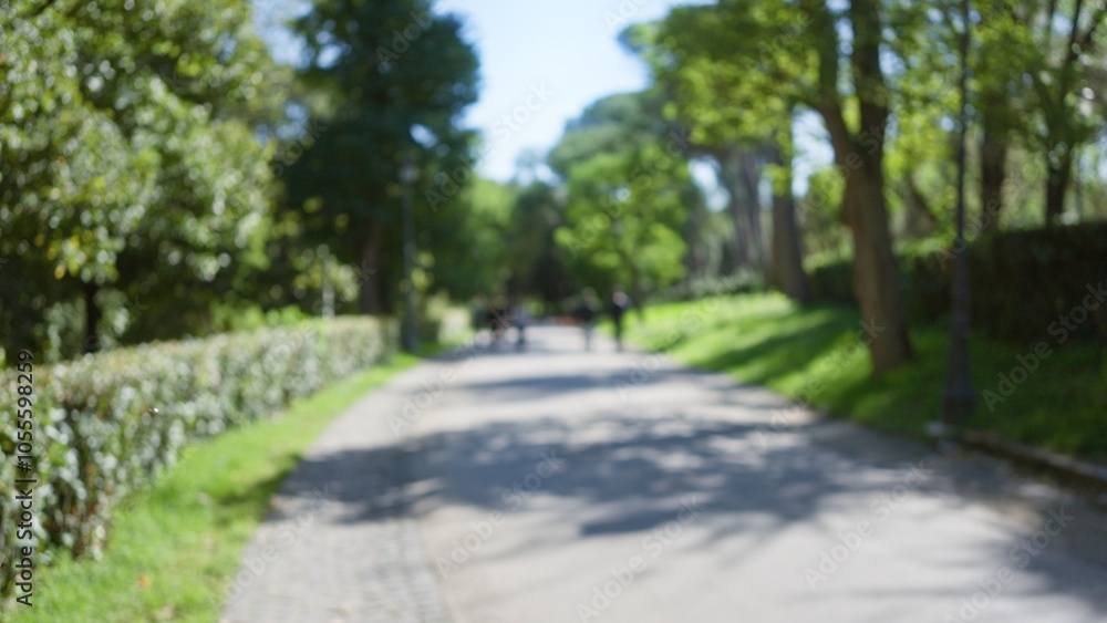 Blurred view of people walking in villa borghese gardens, surrounded by lush greenery in rome, with soft bokeh creating a serene outdoor atmosphere. Blurred view of people walking in villa borghese gardens, surrounded by lush greenery in rome, with soft bokeh creating a serene outdoor atmosphere.