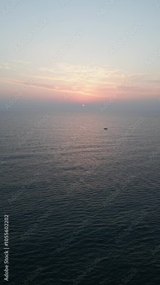 Aerial drone shot of a tranquil sea at sunset with gentle waves and a warm sun descending on the horizon, creating a soothing and picturesque ocean view ideal for relaxation themes Aerial drone shot of a tranquil sea at sunset with gentle waves and a warm sun descending on the horizon, creating a soothing and picturesque ocean view ideal for relaxation themes
