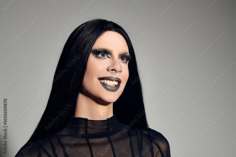 This stylish individual radiates confidence in a sleek black outfit against a grey backdrop, exuding elegance. This stylish individual radiates confidence in a sleek black outfit against a grey backdrop, exuding elegance.