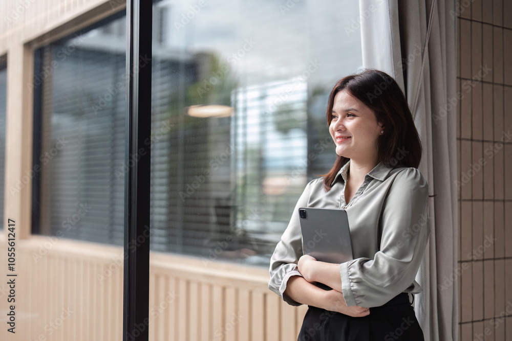 Confident Businesswoman Holding Tablet in Modern Office Setting with Natural Light and Professional Attire Confident Businesswoman Holding Tablet in Modern Office Setting with Natural Light and Professional Attire