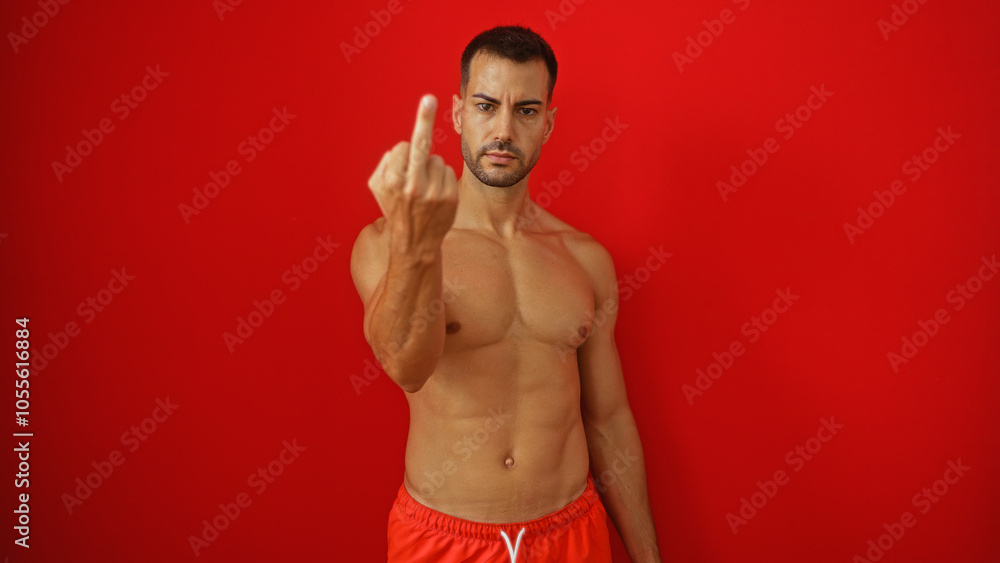 Fototapeta premium Handsome hispanic man with a beard showing a rude gesture isolated over a red background