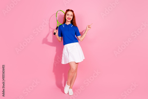 Full length photo of adorable lovely girl wear short skirt enjoying squash pointing empty space isolated pink color background photo