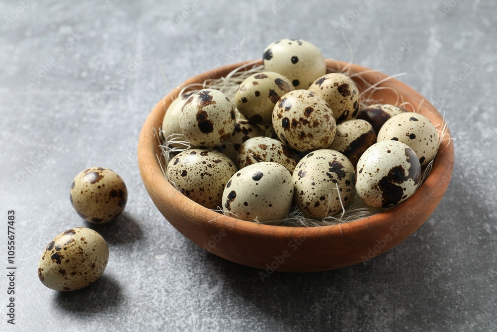 Quail eggs in a plate on gray background 