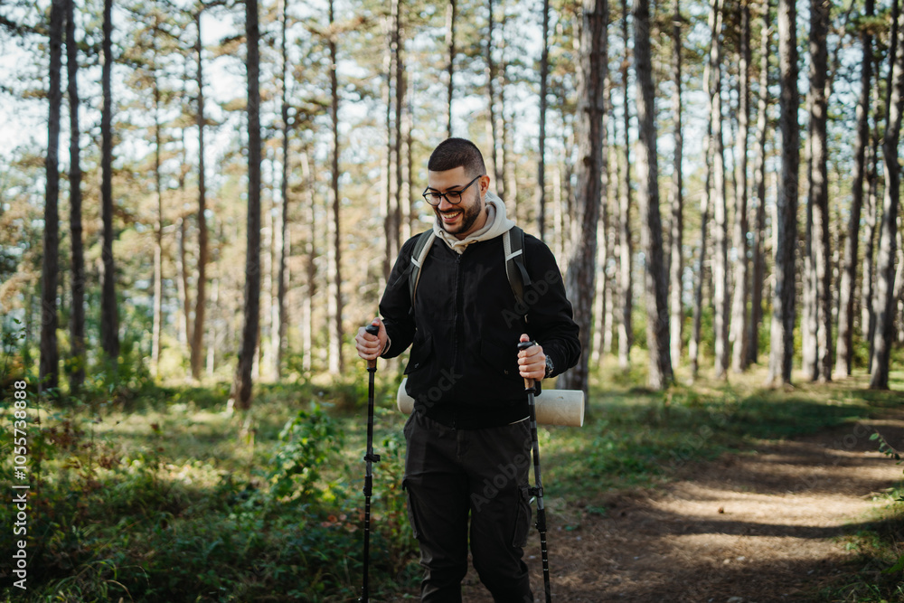 Young caucasian man hiking or trekking through the forest Young caucasian man hiking or trekking through the forest