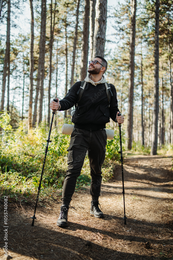 Young caucasian man hiking or trekking through the forest Young caucasian man hiking or trekking through the forest