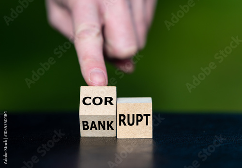 Hand turns cube and changes the expression bankrupt to corrupt.
